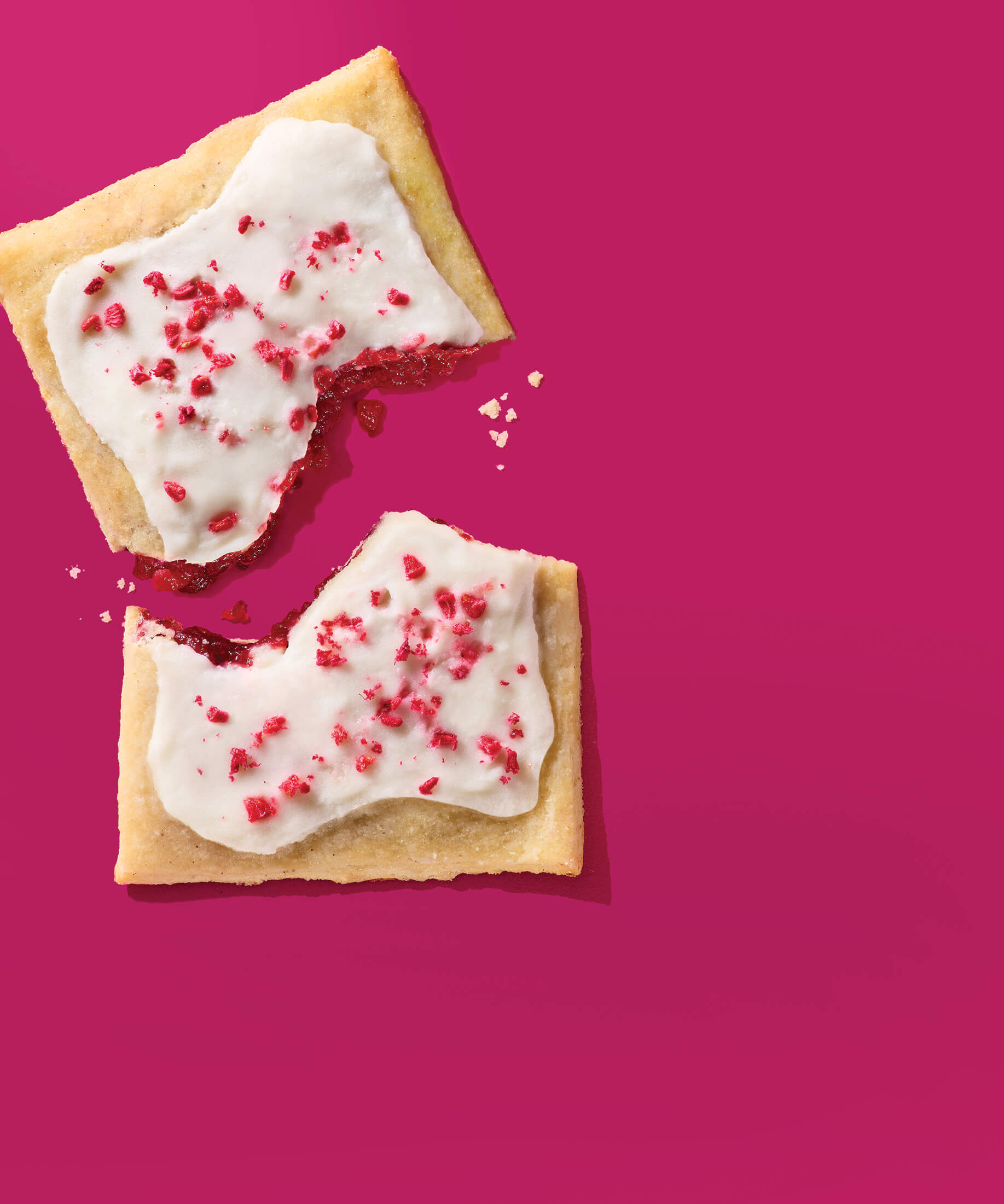 Gluten-free, sugar-free raspberry pastry tart broken in half on magenta background.